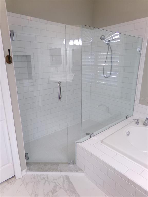 3603 Cypress Meadows Road Tampa, FL 33624 - Photo 20 of 33 a bathroom with a bathtub and shower