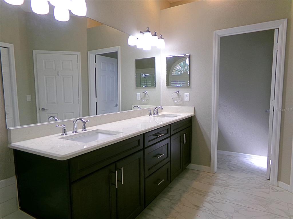 3603 Cypress Meadows Road Tampa, FL 33624 - Photo 21 of 33 a bathroom with a double vanity sink and a mirror