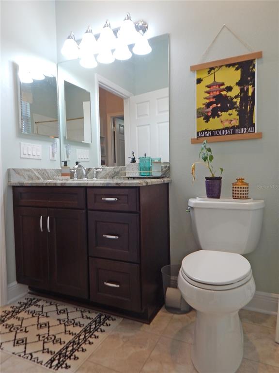 3603 Cypress Meadows Road Tampa, FL 33624 - Photo 23 of 33 a bathroom with a toilet a sink and mirror