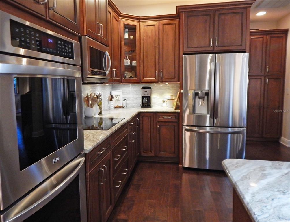 3603 Cypress Meadows Road Tampa, FL 33624 - Photo 8 of 33 a kitchen with stainless steel appliances granite countertop a refrigerator stove and cabinets