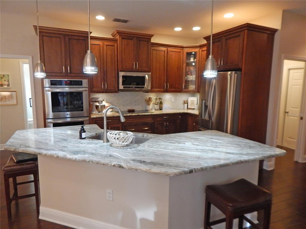 3603 Cypress Meadows Road Tampa, FL 33624 - Photo 9 of 33 a kitchen with kitchen island a sink refrigerator and microwave