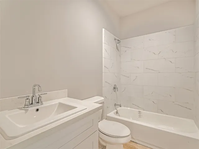 a bathroom with a toilet a sink a mirror and shower