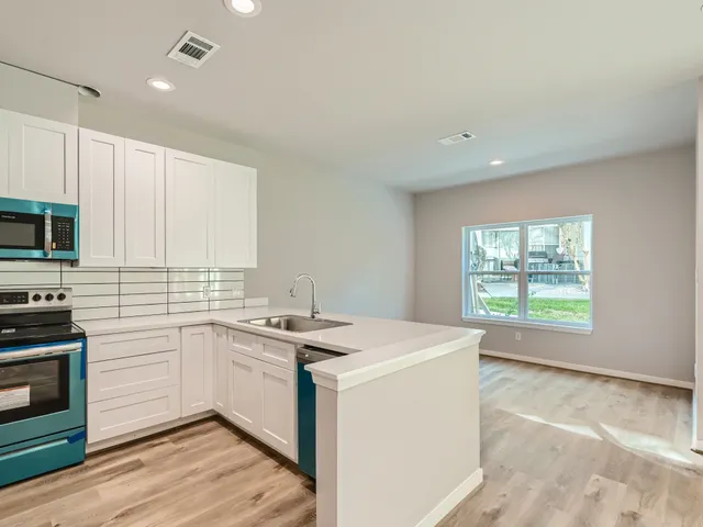 a kitchen with stainless steel appliances a refrigerator sink and microwave