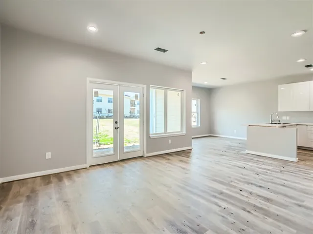 a view of an empty room with wooden floor