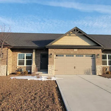 a front view of a house with a yard and outdoor seating