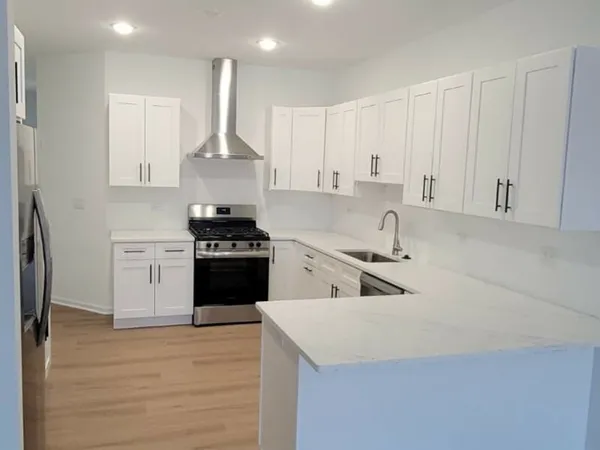 a kitchen with granite countertop white cabinets and stainless steel appliances