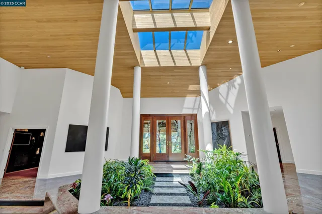 a living room with patio furniture and a garden
