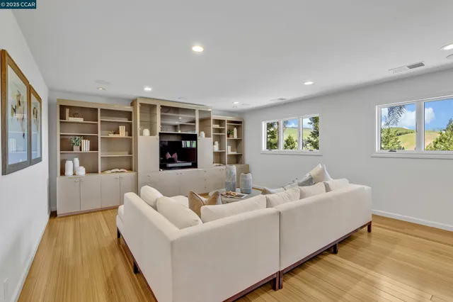 a living room with furniture and a view of kitchen