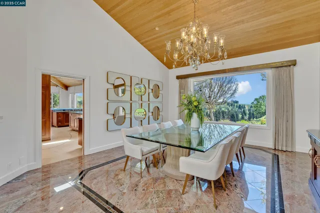 a large living room with stainless steel appliances kitchen island a table and chairs