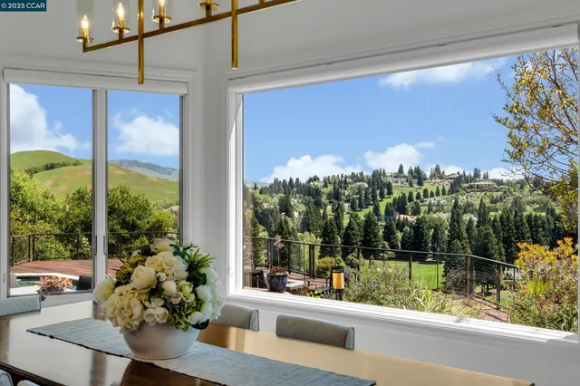 a kitchen with stainless steel appliances granite countertop table chairs stove and refrigerator