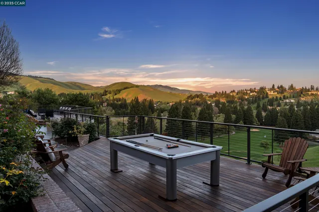 a view of a balcony with dining table and chairs with wooden floor