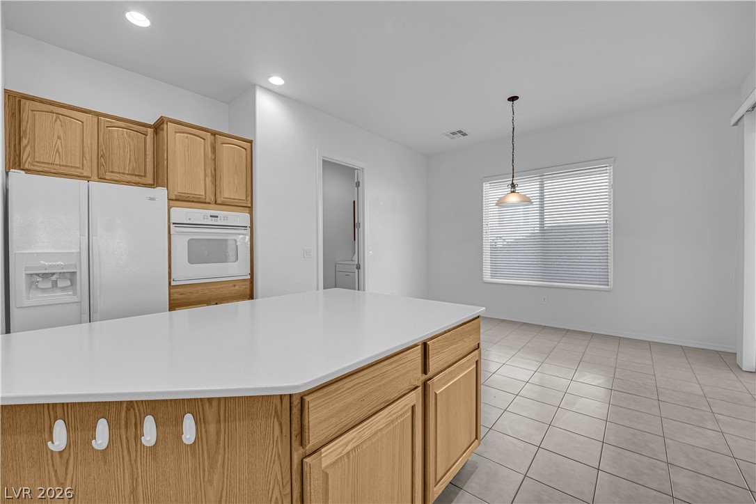 2184 Waterton Rivers Drive Henderson, NV 89044 - Photo 10 of 53 Island Kitchen boasts Corian Countertops, Walk-In Pantry, Recessed Lighting, Breakfast Bar, Large Nook, Tile Flooring, Refrigerator, Gas Cooktop, Built-In Oven, Microwave and Dishwasher