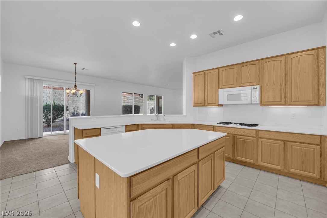 2184 Waterton Rivers Drive Henderson, NV 89044 - Photo 8 of 53 Island Kitchen boasts Corian Countertops, Walk-In Pantry, Recessed Lighting, Breakfast Bar, Large Nook, Tile Flooring, Refrigerator, Gas Cooktop, Built-In Oven, Microwave and Dishwasher