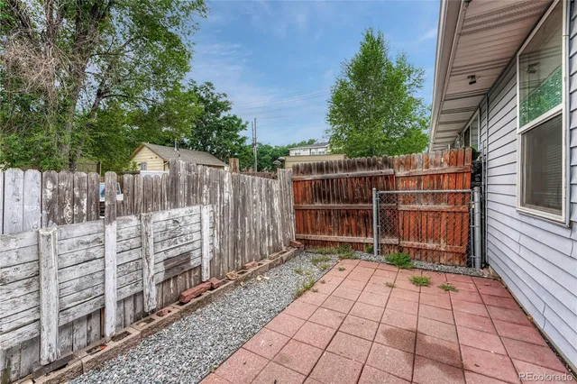 a view of a house with backyard and sitting area