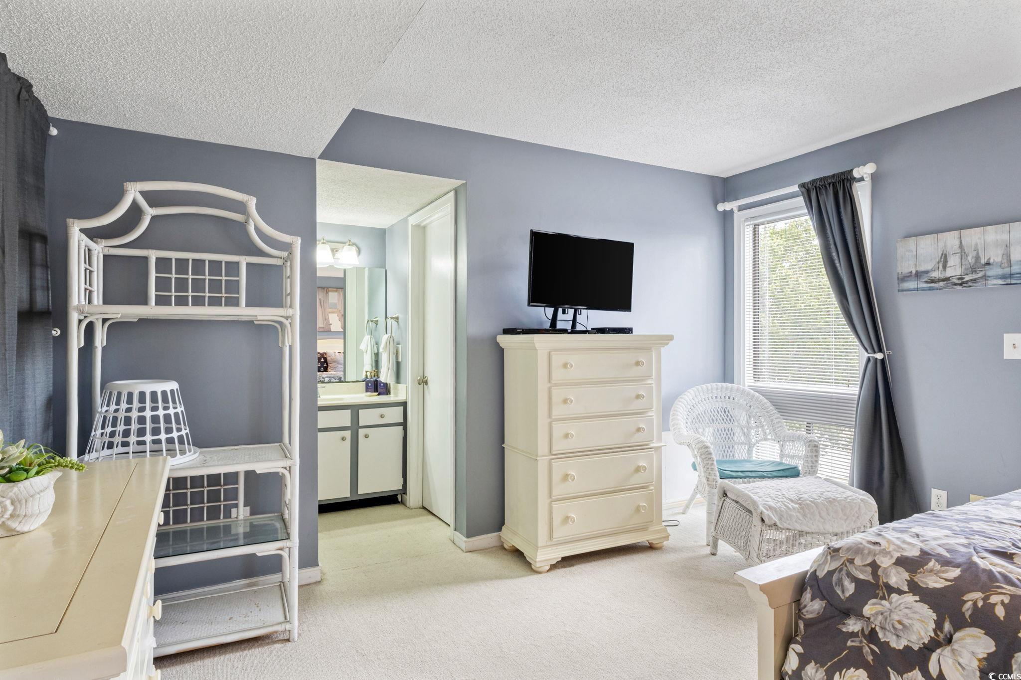 351 Lake Arrowhead Road, Unit 2206 Myrtle Beach, SC 29572 - Photo 15 of 40 Bedroom with light colored carpet, a textured ceiling, and ensuite bath