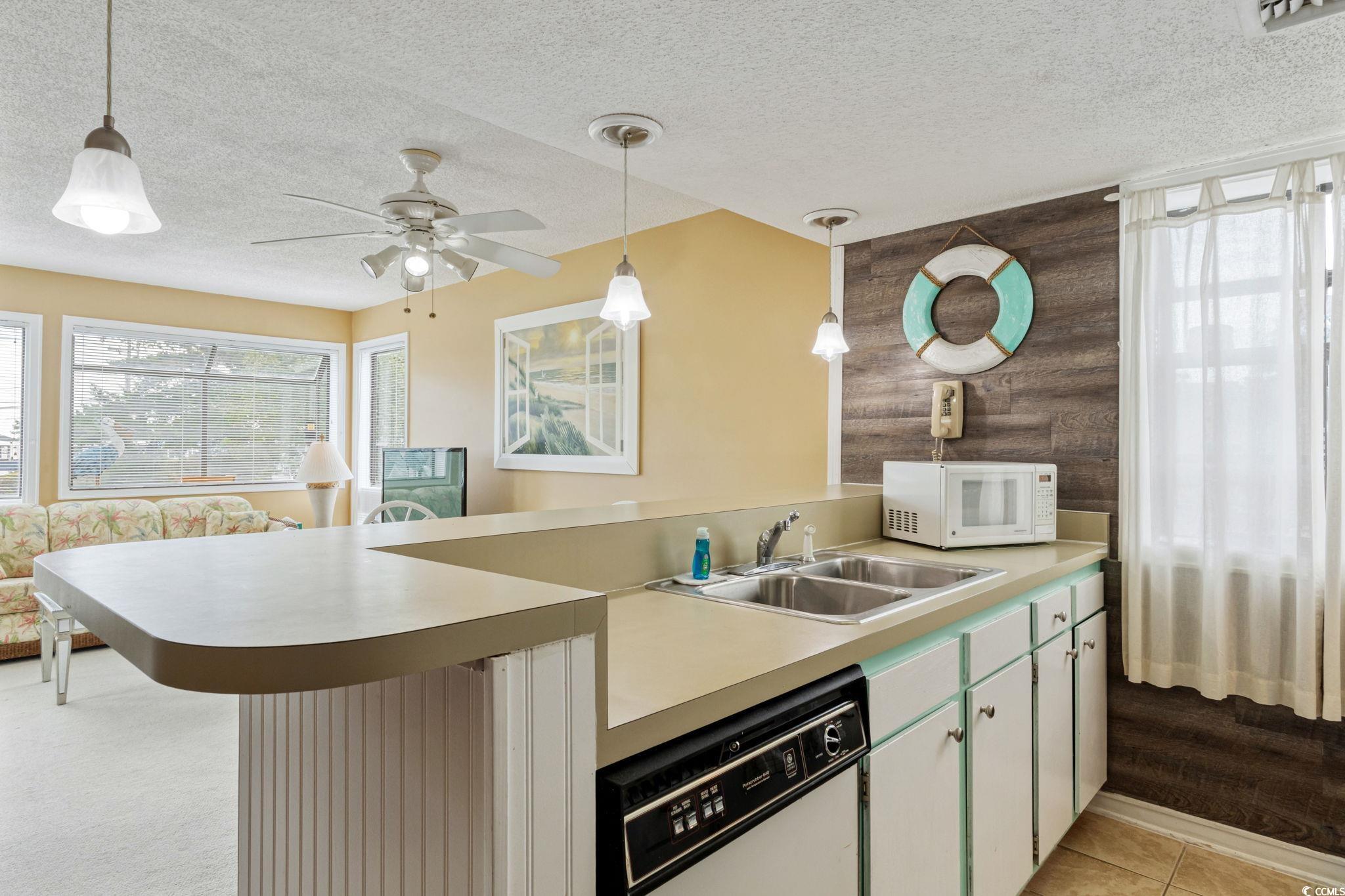 351 Lake Arrowhead Road, Unit 2206 Myrtle Beach, SC 29572 - Photo 8 of 40 Kitchen with plenty of natural light, light countertops, white appliances, decorative light fixtures, and a textured ceiling
