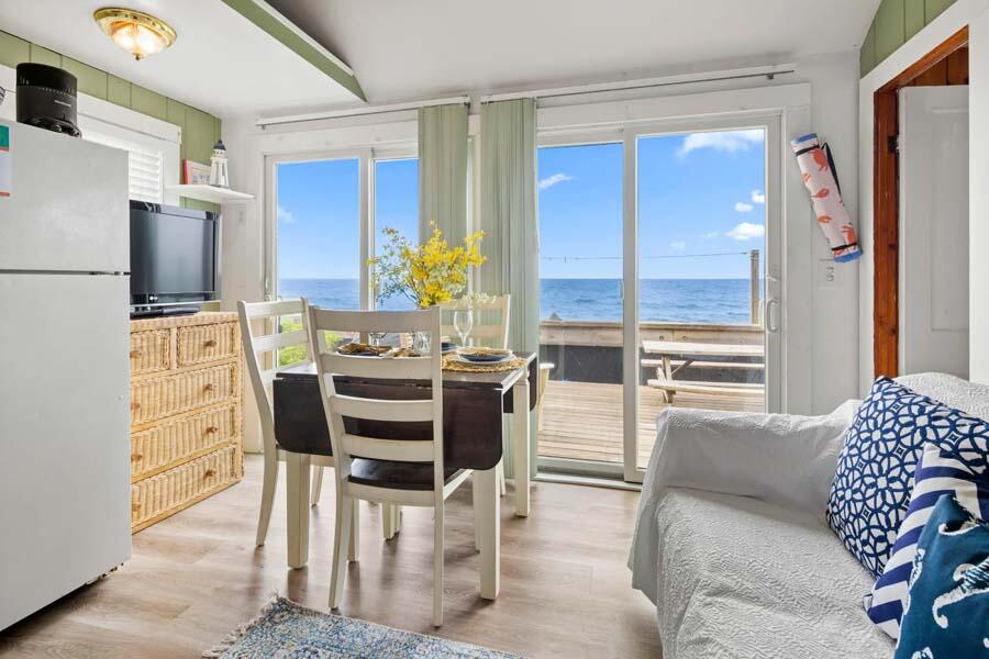 334 Shore Road, Unit 12 Truro, MA 02666 - Photo 11 of 19 a view of a dining room with furniture a chandelier and wooden floor