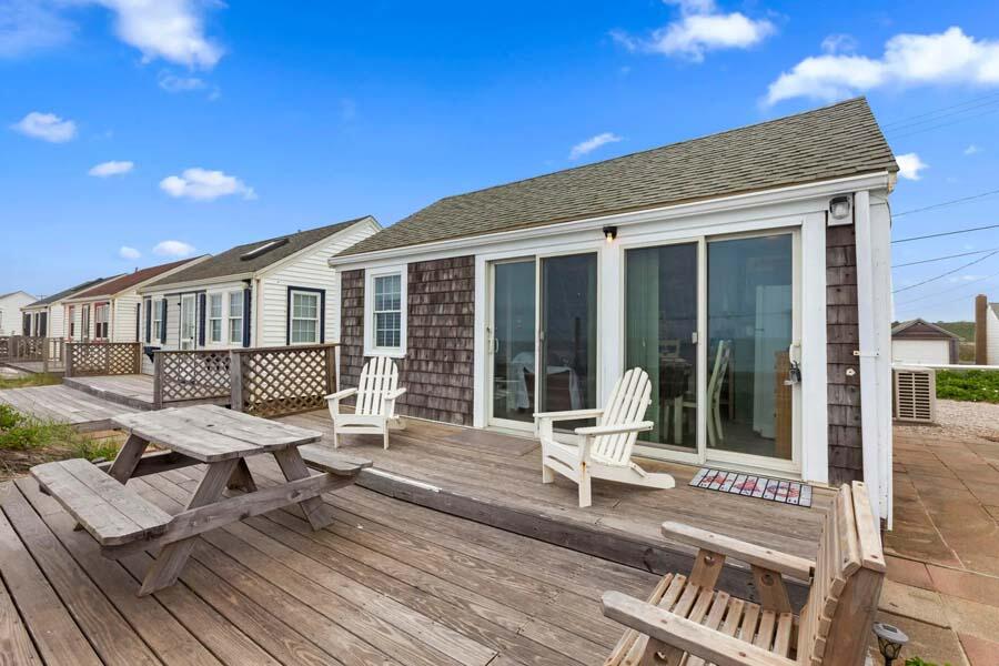 334 Shore Road, Unit 12 Truro, MA 02666 - Photo 2 of 19 a view of a deck with table and chairs with wooden floor and fence
