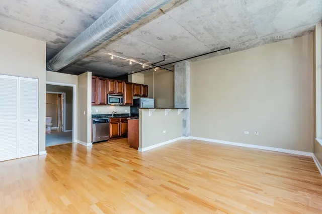 a view of a kitchen with stainless steel appliances wooden floor and a large window