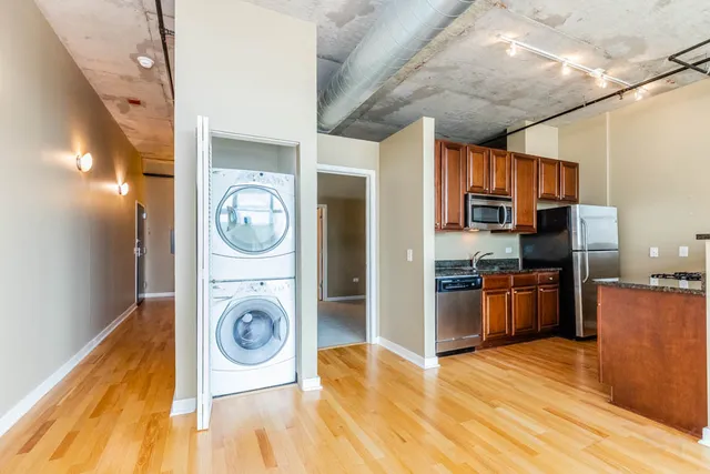 a view of a kitchen with a stove fridge and wooden floor