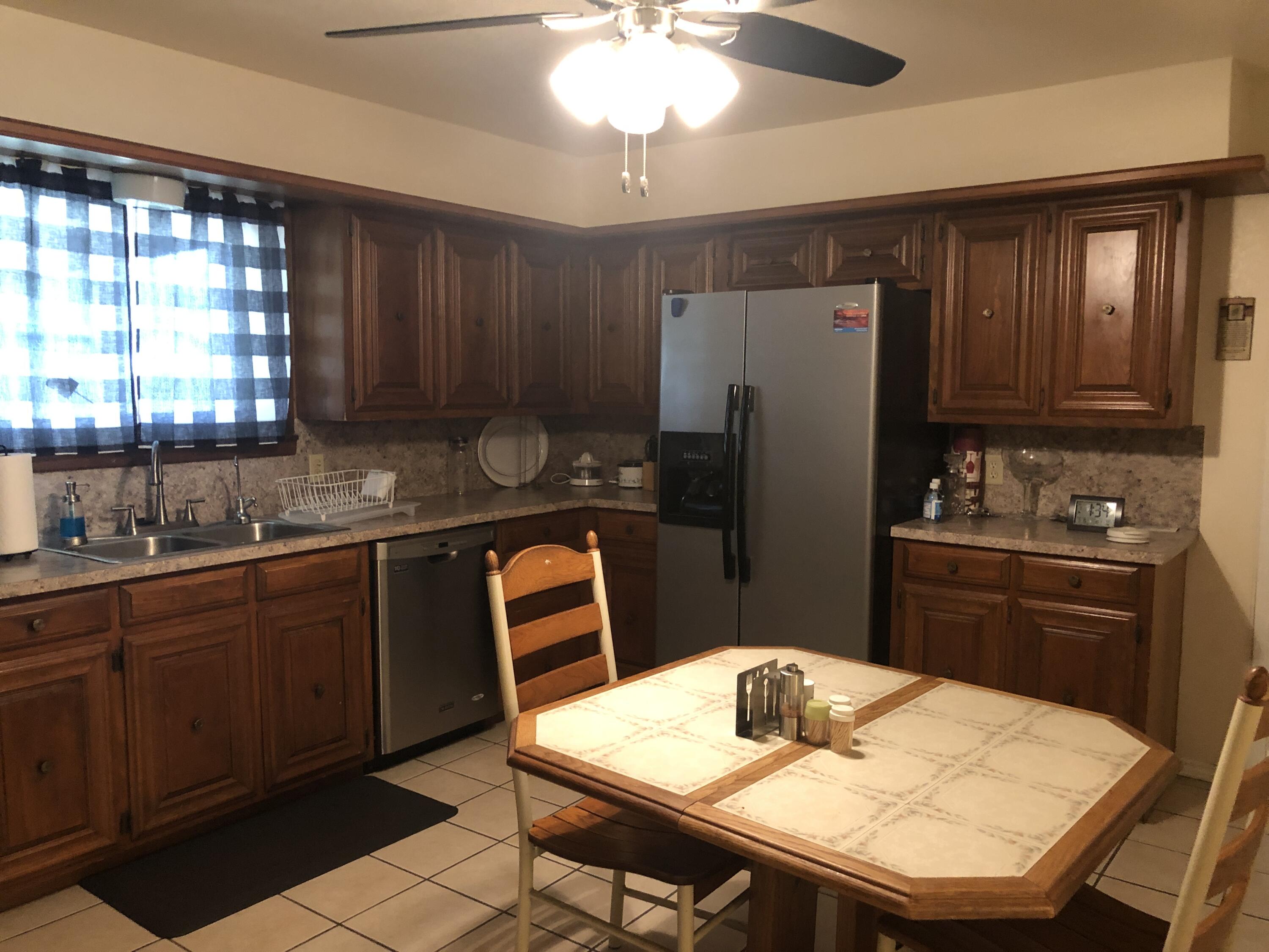 804 South Broadway Plainview, TX 79072 - Photo 15 of 46 a kitchen with stainless steel appliances granite countertop a refrigerator a sink a stove a dining table and chairs