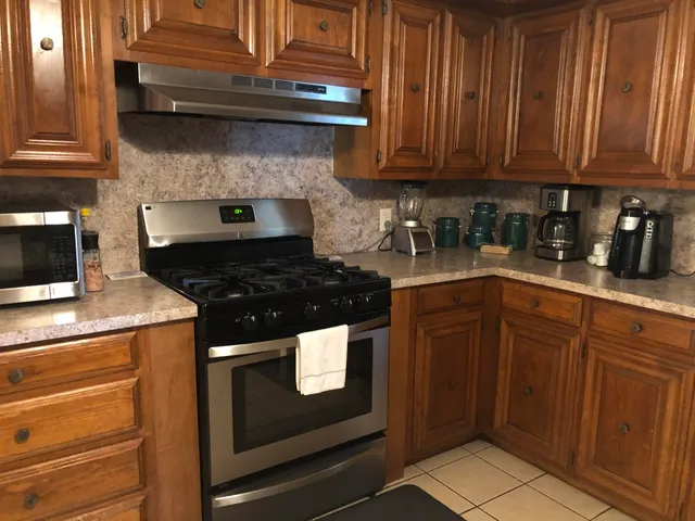 a kitchen with granite countertop wood cabinets and stainless steel appliances