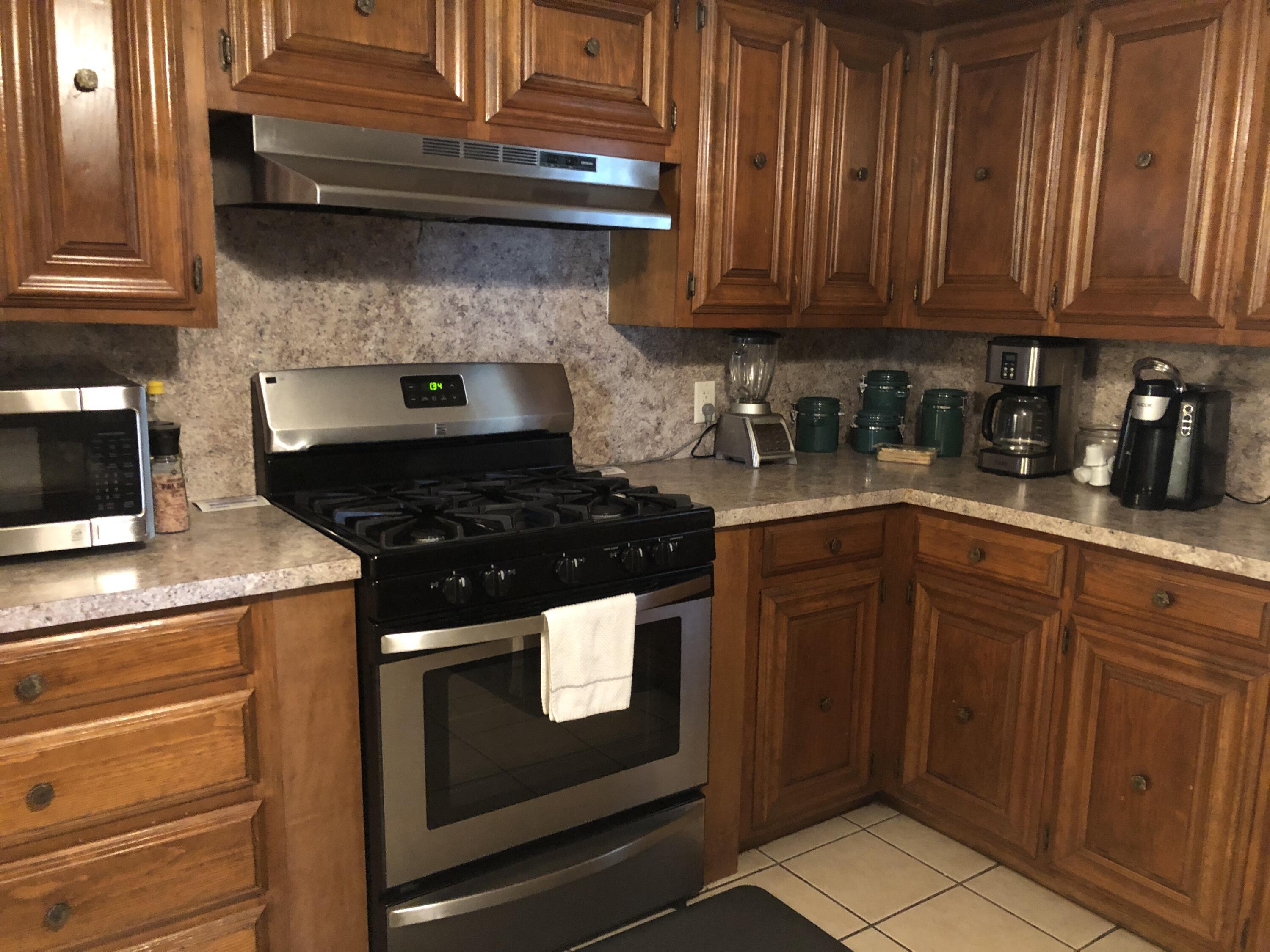 804 South Broadway Plainview, TX 79072 - Photo 16 of 46 a kitchen with granite countertop wood cabinets and stainless steel appliances