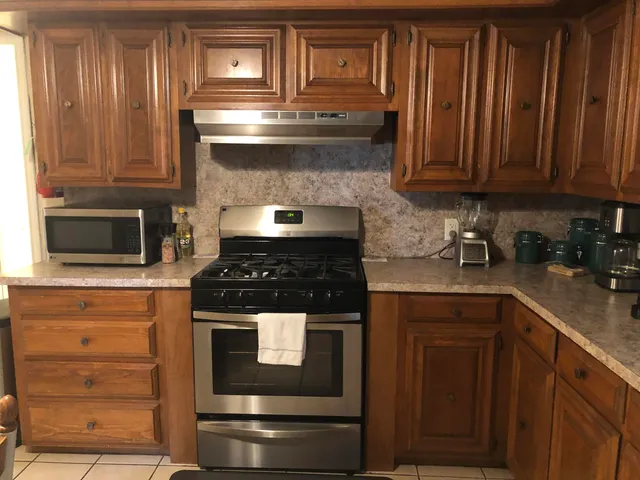 a kitchen with granite countertop wood cabinets and stainless steel appliances