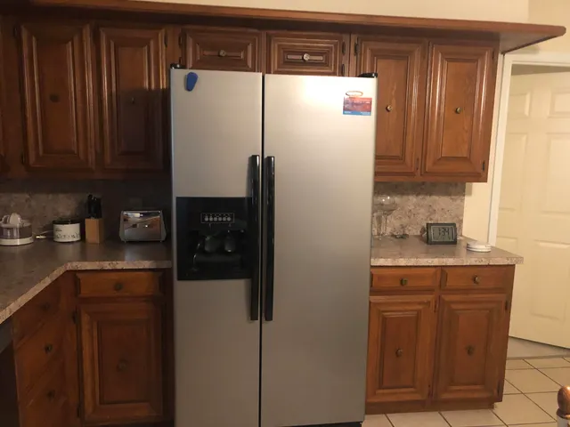 a kitchen with a refrigerator and cabinets