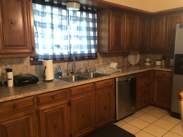 a kitchen with stainless steel appliances granite countertop wooden cabinets a sink and dishwasher
