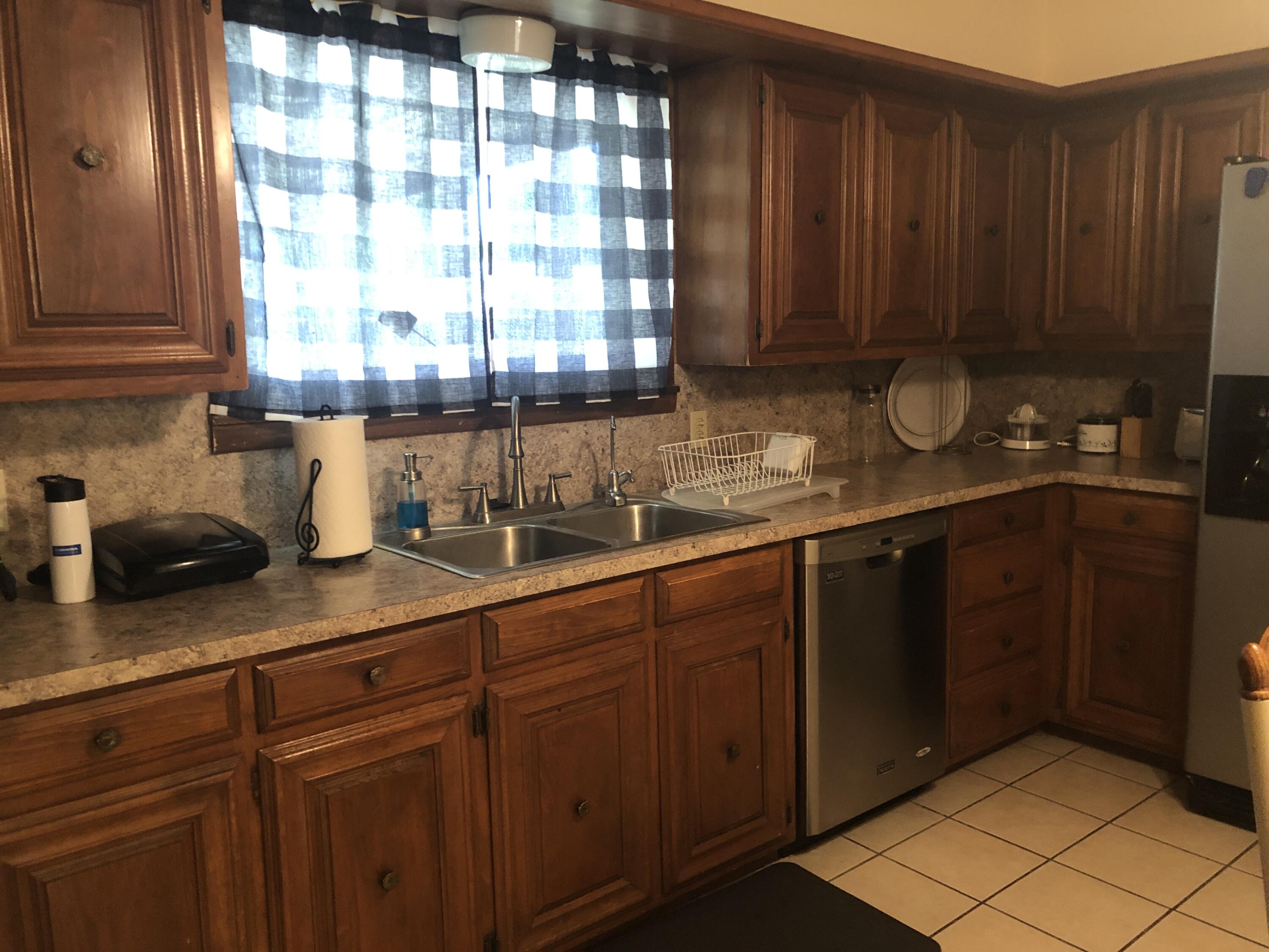 804 South Broadway Plainview, TX 79072 - Photo 20 of 46 a kitchen with stainless steel appliances granite countertop wooden cabinets a sink and dishwasher