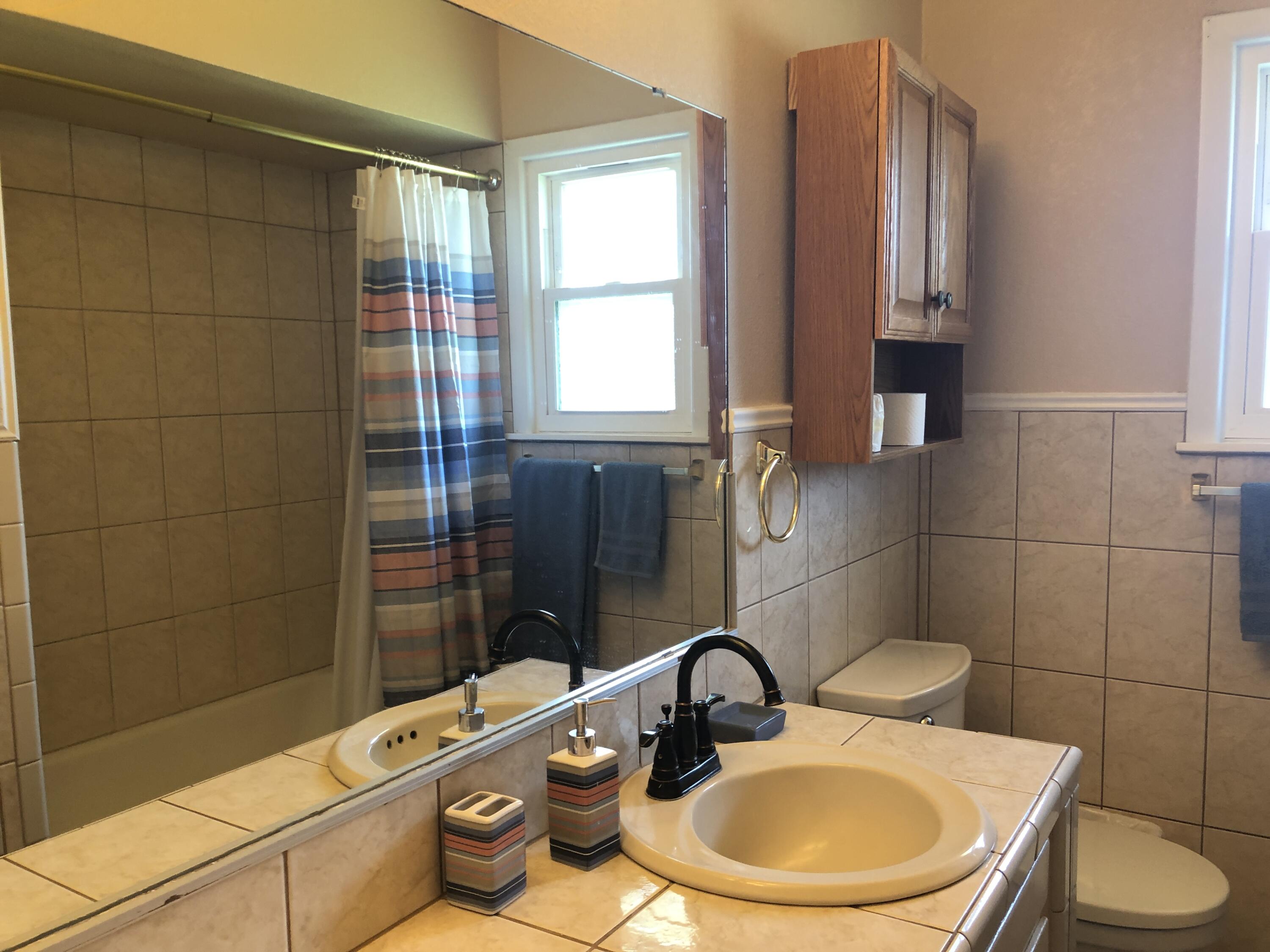 804 South Broadway Plainview, TX 79072 - Photo 21 of 46 a bathroom with a sink mirror toilet and shower