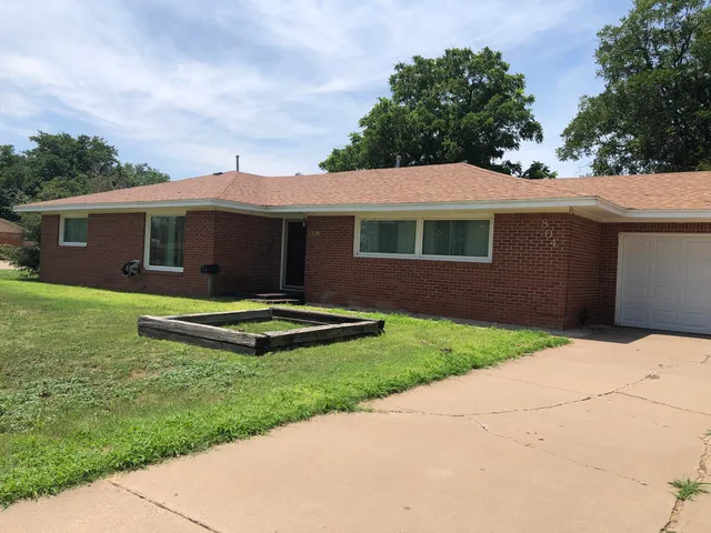 a view of a house with backyard and garden