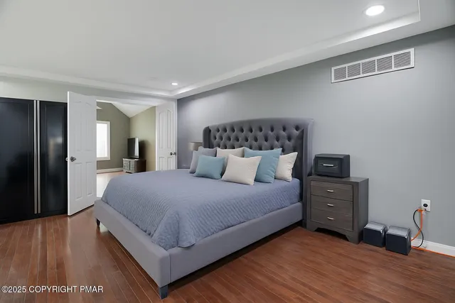 a bedroom with a bed and wooden floor