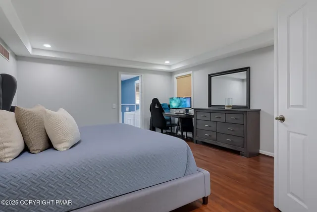 a bedroom with a large bed and wooden floor