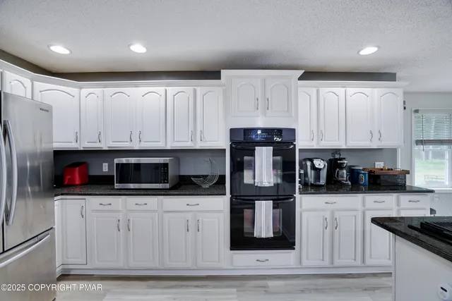 a kitchen with stainless steel appliances a stove a sink and cabinets