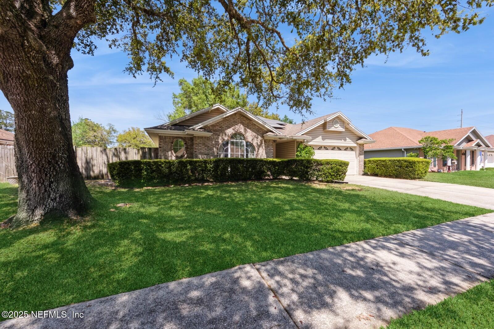 a front view of a house with yard and green space