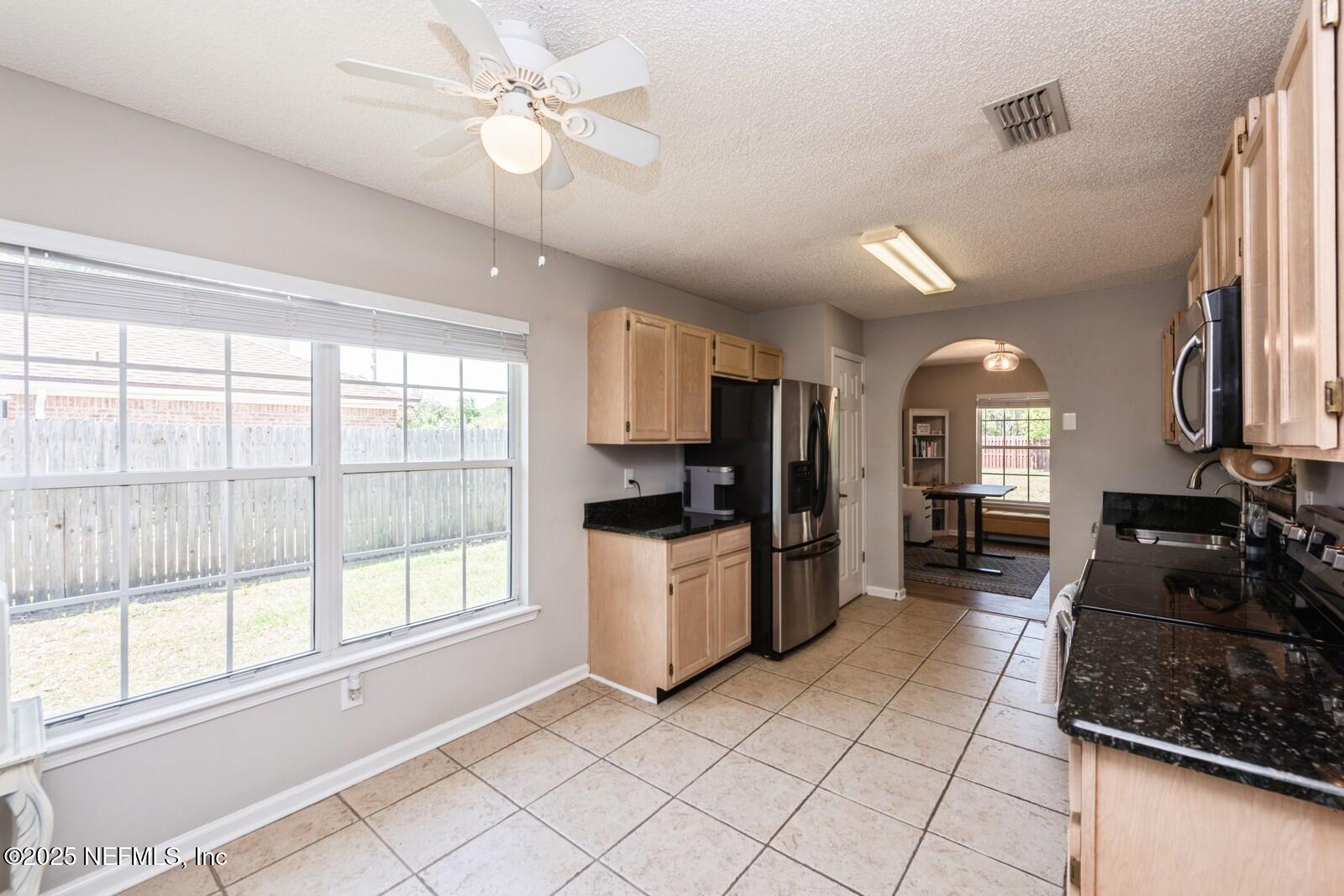 1962 Little River Drive Fleming Island, FL 32003 - Photo 11 of 29 a kitchen with stainless steel appliances granite countertop a refrigerator a sink dishwasher a stove and white countertops with wooden floor