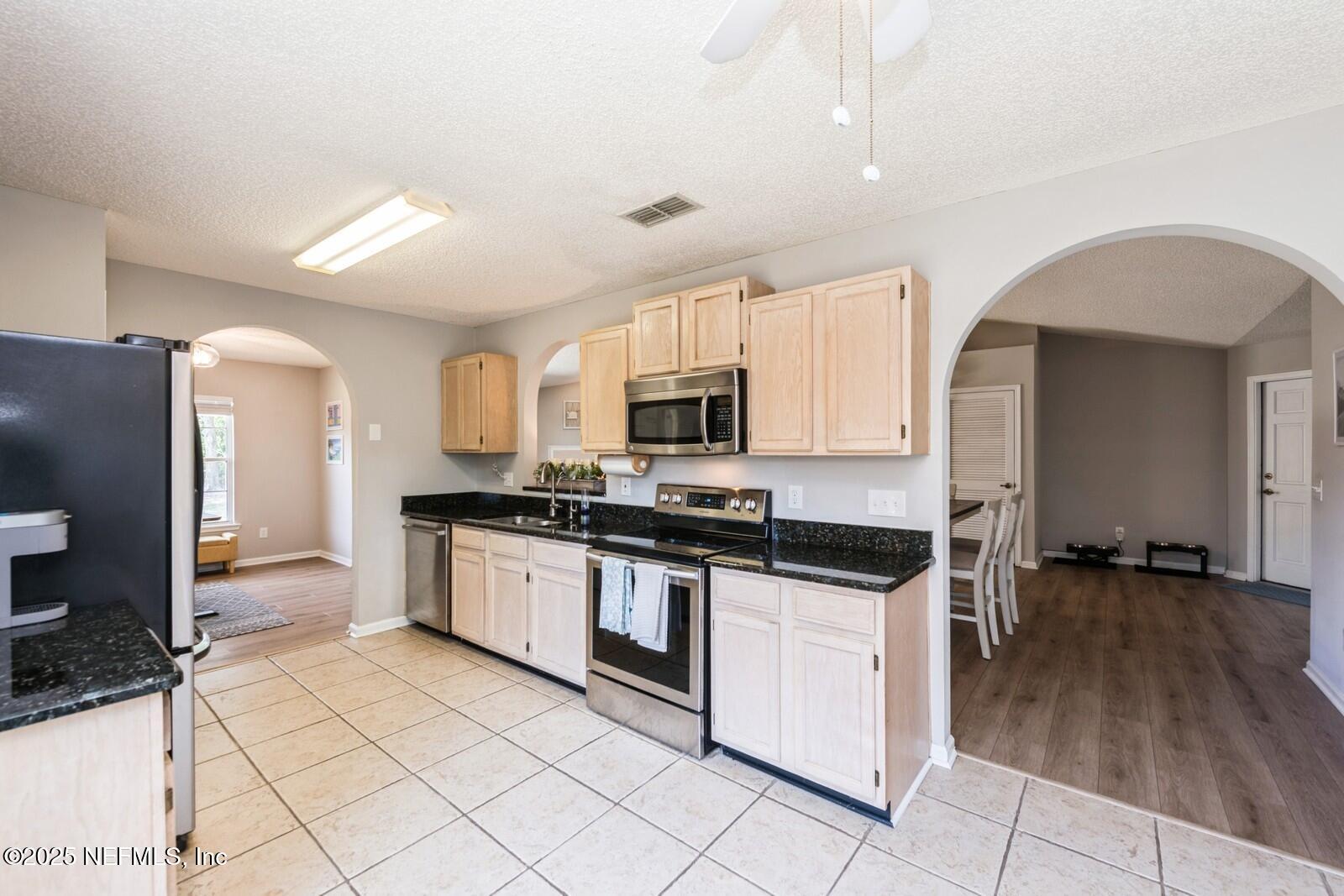 1962 Little River Drive Fleming Island, FL 32003 - Photo 12 of 29 a kitchen with granite countertop a stove top oven and cabinets