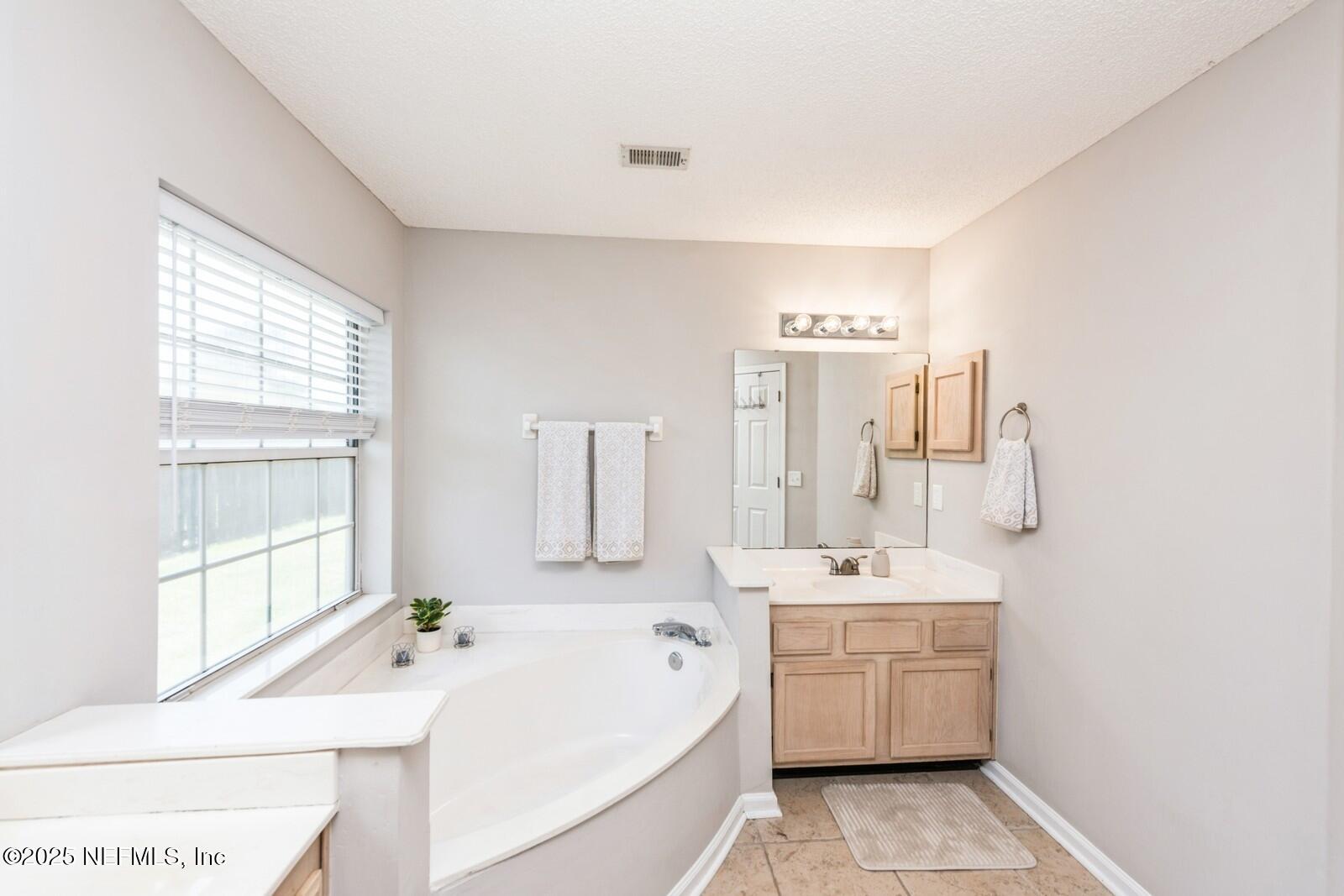 1962 Little River Drive Fleming Island, FL 32003 - Photo 18 of 29 a bathroom with a tub sink and mirror