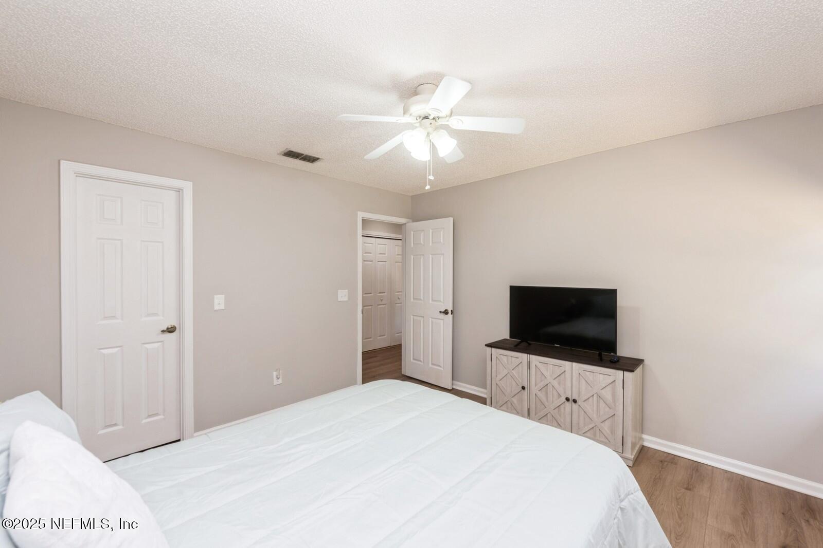 1962 Little River Drive Fleming Island, FL 32003 - Photo 21 of 29 a bedroom with a flat screen tv and a chandelier fan