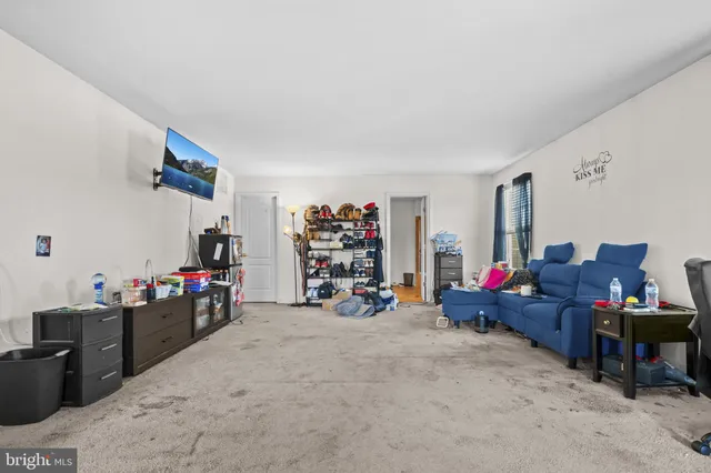 a living room with lots of furniture and clutter