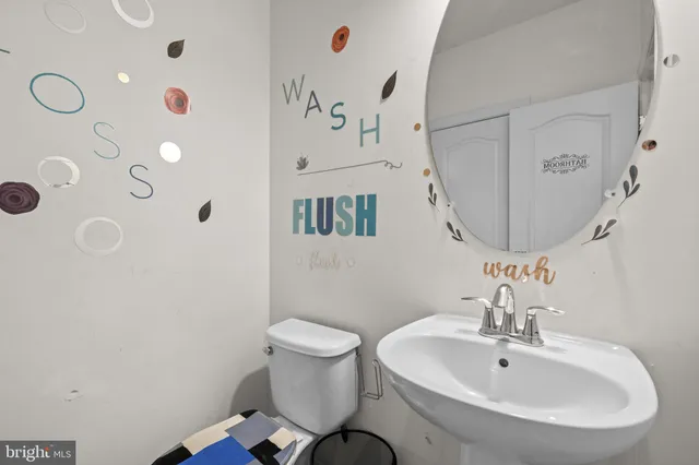 a bathroom with a sink mirror and toilet