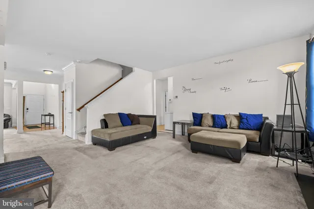 a living room with furniture and a ceiling fan