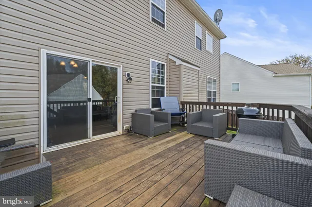 a roof deck with couches and wooden floor