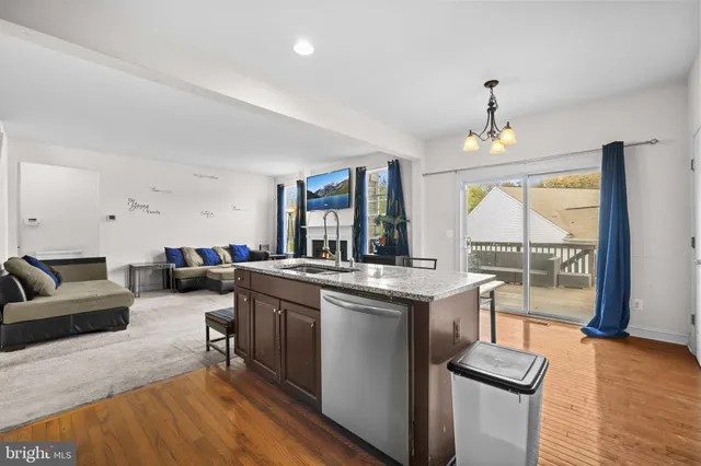 a living room with furniture a large window and wooden floor