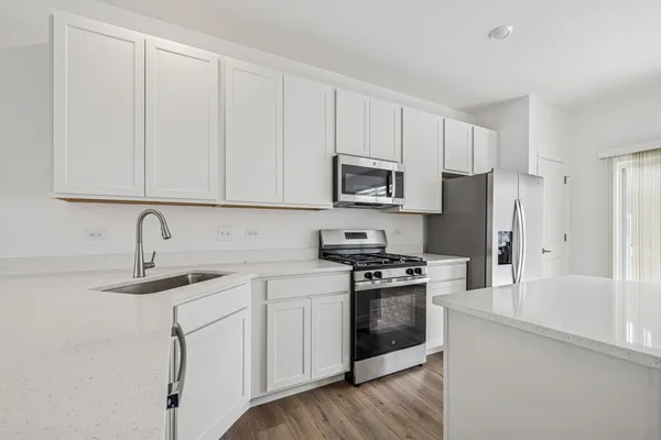 a kitchen with white cabinets sink and stainless steel appliances