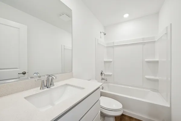 a bathroom with a sink a toilet and a large mirror