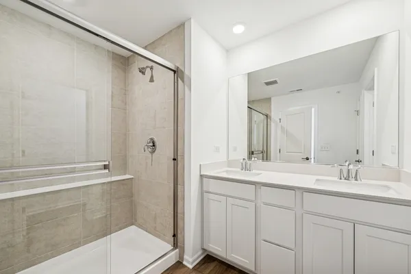 a bathroom with a double vanity sink mirror and shower