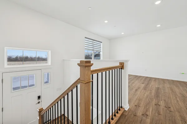 a view of staircase with railing and white walls